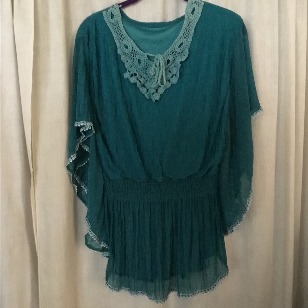 Turquoise top with crochet pattern on the bottom.